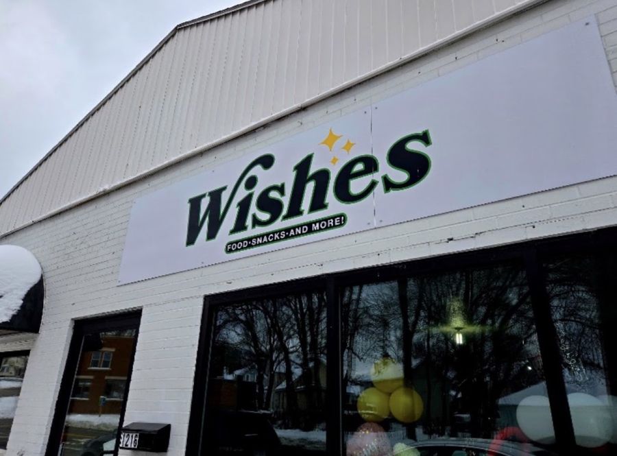 The white brick Wishes building with its green Wishes, Food, Snacks and More sign